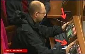 Ukrainan pääministeriksi vallankaappauksen yhteydessä noussut Arseni Jatsenjuk äänestää kuvassa kahdella laitteella yhtä aikaa. Kuva esitettiin vain harvassa länsimediassa.